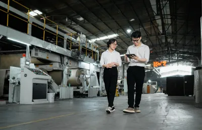 Hai kỹ sư đi kiểm tra dây chuyền trong xưởng sản xuất của Minh Phúc