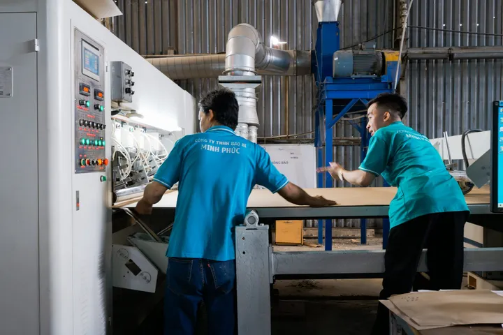 Công nhân Minh Phúc kiểm tấm carton trên chuyền trong quá trình làm hàng mẫu