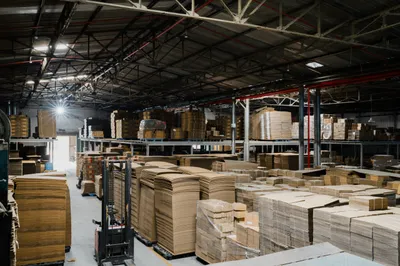 Kho thành phẩm với các kiện thùng carton xếp cao chờ xuất hàng